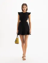 Vestido corto negro con escote redondo, volados en las sisas, aberturas laterales en la cintura y falda evasé con volado en el ruedo.