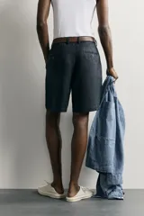 Bermuda regular fit azul marino confeccionada en lino, con bolsillos frontales, bolsillos traseros de doble vivo con botón y cierre frontal con cremallera y botón.