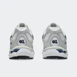 Championes Asics modelo Gel Nyc, en color blanco con detalles en gris claro y azul marino. Confeccionados con malla transpirable y superposiciones sintéticas, con tecnología GEL en la suela para mayor comodidad.