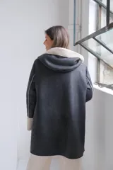 Tapado de cuero sintético negro con interior y detalles en corderito sintético color crema. Presenta capucha, cierre frontal y mangas largas con puños vueltos.