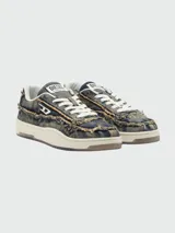 Zapatillas Diesel modelo S-Tracker-D Low, confeccionadas en denim con efecto desgastado y bordes desflecados. Presentan cordones blancos, suela de goma color crema y el logo de la marca en el lateral y la lengüeta.