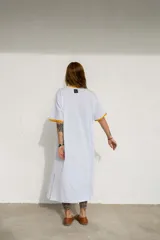 Vestido largo marrón con cuello redondo y mangas cortas con ribete amarillo. Estampado frontal con letras en color crema.