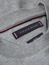 Remera gris de algodón con cuello redondo y logo de Tommy Hilfiger bordado en el pecho.