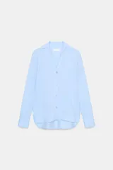 Camisa de manga larga color marrón oscuro, con cuello solapa, escote pico pronunciado y bajo asimétrico redondeado.