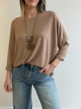 Sweater de punto fino y suave, color gris melange, con diseño amplio y relajado, escote redondo y mangas largas.