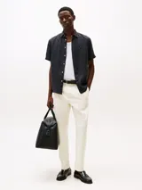 Camisa de manga corta azul marino de lino con corte regular, cuello con botones y logo de Tommy Hilfiger bordado en el pecho.