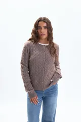 Saco de tejido de punto color tostado, con diseño de trenzas en todo el cuerpo y mangas, cuello redondo y cierre frontal con botones.
