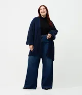 Cardigan abierto de punto pesado con textura peludita, manga larga y diseño alargado. Prenda versátil de corte holgado.
