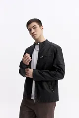 Campera de cuero sintético color negro, con cuello mao, cierre frontal y bolsillos laterales con cierre. Presenta detalles de costuras acolchadas en los hombros y un bolsillo pequeño con cierre en el pecho.