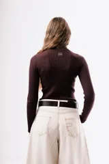 Polera de punto acanalado en color marrón chocolate, con cuello alto y mangas largas ajustadas.