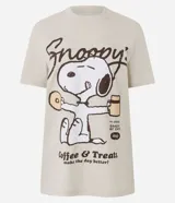 Remera de algodón color beige con cuello redondo y mangas cortas. Presenta una estampa frontal centrada del personaje Snoopy sosteniendo una taza y una dona, acompañada por el texto 'Snoopy's Coffee & Treats'.