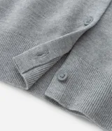 Cardigan gris de punto con cuello redondo, manga larga ajustada y bajo ajustado. Cierre frontal con botones.