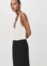 Falda midi tiro medio de color negro, con diseño cruzado y tajo delantero.