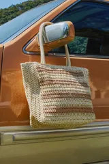 Bolso tipo tote de tejido trenzado en tonos beige y marrón, con diseño de rayas horizontales y doble asa de hombro.