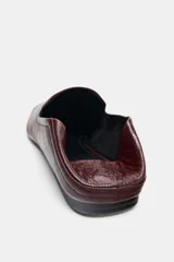 Zapato plano tipo slipper confeccionado en piel color bordó, con diseño de copete subido, punta cuadrada y talón flexible que permite su uso como destalonado.