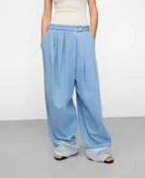 Pantalón baggy de denim de algodón orgánico y reciclado, color celeste claro, con pliegues frontales, bolsillos laterales y dobladillo vuelto en la parte inferior.