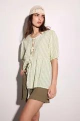 Blusa de lino y viscosa con estampado de rayas verticales blancas y verdes, de calce holgado y escote redondo con cierre de tiras atadas al frente. Cuenta con mangas cortas abullonadas.