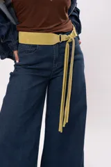 Faja de cuero gamuza color pistacho, con diseño curvado, herrajes plateados y cierre de nudo con flecos largos.