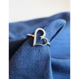 Anillo de plata 925 con diseño de corazón calado adornado con pequeñas zirconias brillantes.