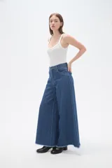 Pantalon de jean azul de corte ancho y tiro alto, con ruedo deshilachado.