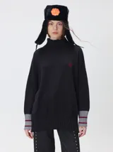 Pullover de cuello tortuga color marrón, de corte holgado y diseño básico. Presenta puños acanalados en contraste de color bordó con líneas horizontales celestes.