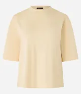 Remera color crema de corte cuadrado y mangas cortas, confeccionada en algodón.