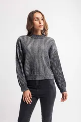 Buzo de tejido de punto con diseño de rayas verticales en contraste, cuello redondo y mangas largas con puños ajustados.