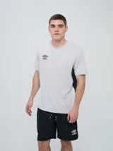 Remera deportiva Umbro modelo Vant, de color negro con paneles laterales grises y cuello redondo, diseñada para hombre.
