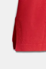 Remera oversize de punto rojo, con cuello redondo y mangas de largo medio por debajo del codo, diseño holgado y amplio.