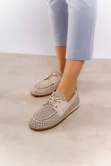 Náuticos color beige con diseño calado geométrico, cordones decorativos y suela marrón.