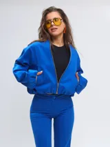 Campera tipo bomber color azul francia, con cuello a la base, cierre frontal completo, bolsillos ojal y mangas largas abullonadas. Confeccionada en gabardina de algodón.