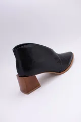 Botines de cuero color beige con diseño de tajo frontal, punta fina y taco cuadrado de madera.