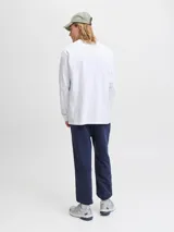 Remera de manga larga con cuello redondo y calce relajado, confeccionada en algodón orgánico. Presenta un diseño minimalista con un pequeño logo estampado en el centro del pecho.