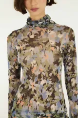 Top de tul estampado con diseño floral, cuello alto y mangas largas, de corte ajustado y tejido semitransparente.
