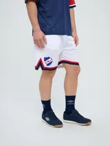Short deportivo Umbro del Club Nacional de Football, modelo Match para hombre. Diseño en color azul marino con tejido de malla, detalles en blanco y rojo en los laterales y el escudo del club bordado.