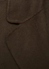 Abrigo largo de diseño recto confeccionado en tejido mezcla de lana. Presenta cuello con solapa, cierre frontal mediante cinturón tipo batín, manga larga y abertura posterior en el bajo.