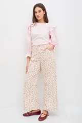 Blusa de algodón color rosado, con mangas largas abullonadas, volados en los hombros y puños elásticos con terminación en volado.