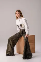 Jean wide leg de tiro alto con efecto desteñido en tonos verdosos y oscuros, de corte amplio y acampanado.