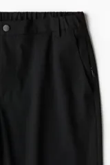 Pantalón de corte ajustado con cierre y botón, bolsillos laterales y bolsillo trasero insertado.