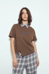 Remera blanca de manga corta con cuello redondo, aberturas laterales y bordado frontal con la frase "LIMITED EDITION" en negro.