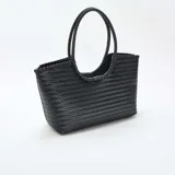 Bolso tipo shopper de gran tamaño, confeccionado con un diseño trenzado en color negro, con asas fijas también trenzadas y estructura rectangular.