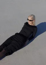 Falda larga negra con tajo lateral y pretina con trenza de terciopelo.