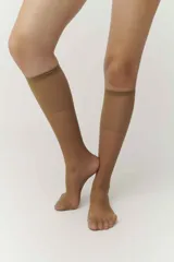 Medias 3/4 de lycra color beige, con puntera reforzada y terminación elástica en la rodilla.