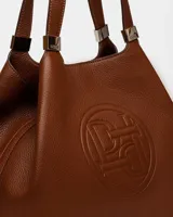 Bolso de hombro azul marino de cuero graneado con logo grabado en el centro.