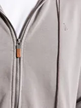 Canguro gris con cierre frontal, capucha con cordones ajustables y logo bordado en el pecho.