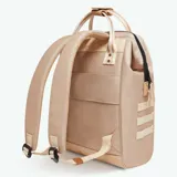 Mochila Cabaia modelo Adventurer Lobito, color beige con detalles en marrón claro y tiras blancas con rayas beige. Cuenta con un compartimento principal con cierre, un bolsillo frontal con cierre y un compartimento acolchado para laptop. Las asas superiores son de tela y tiene correas ajustables para la espalda.