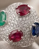 Anillo de plata 925 con diseño bombe, completamente pavimentado con circonias blancas y decorado con cuatro piedras naturales ovaladas: rubí, esmeralda y zafiro azul.