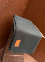 Bufanda de lana color gris oscuro con etiqueta de cuero cosida en un extremo que presenta el logo de la marca SierraMora.