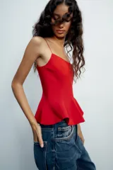 Top negro de escote redondo con tirantes finos y diseño peplum.