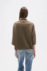 Polera de corte holgado en color verde oliva, con cuello alto y mangas tres cuartos.